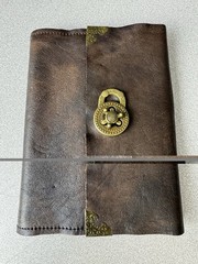 Handcrafted vintage-style brown leather journal with a bronze metal clasp.